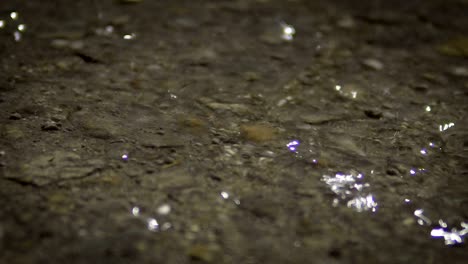 gotas de lluvia en el suelo de asfalto por la noche, fondo en bucle