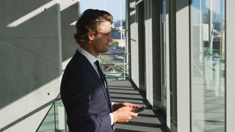 Businessman-using-smartphone-in-a-modern-office-building