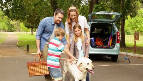 Familie-Ruft-Ihren-Hund-Vor-Einem-Picknick-Aus-Dem-Auto