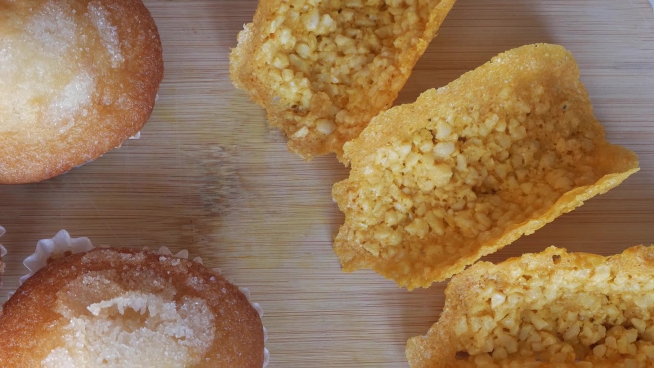 Close-up de muffins e salgados sobre madeira, ambiente acolhedor e saboroso