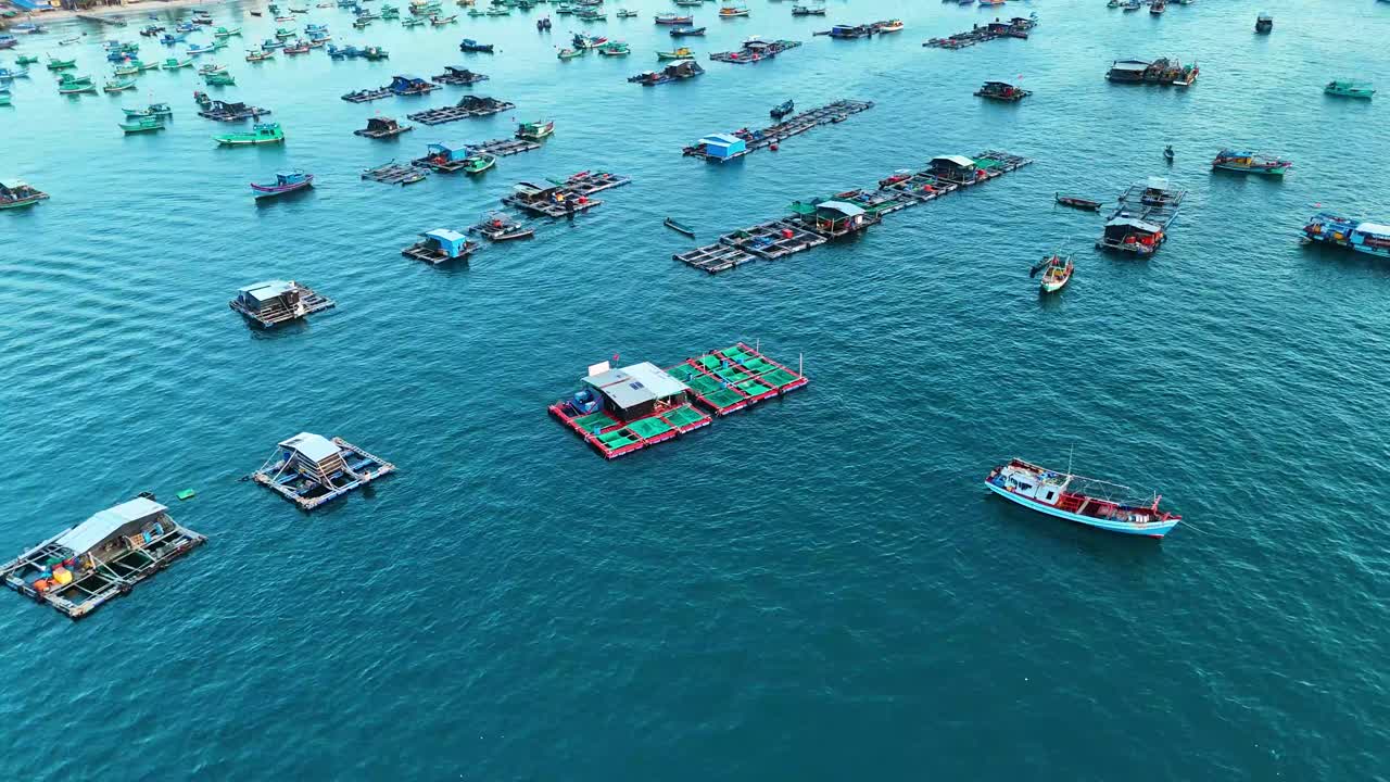 Aerial view of fishing boats and floating aqua farming platforms in the waters of Phu Quoc Island, Vietnam. The unique aquatic farming industry against the backdrop of calm blue waters.
