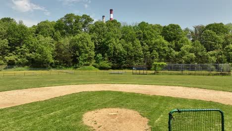 Una-Vista-De-ángulo-Bajo-De-Un-Campo-De-Béisbol-Vacío-En-Un-Día-Soleado-Con-Cielos-Azules-Y-Nubes-Blancas