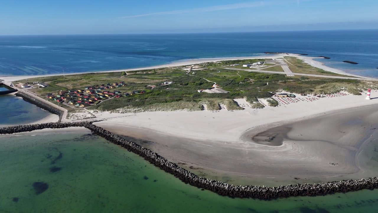 Sirkulerende droneutsikt rundt øya Düne med strandhus, sand og strandlinje