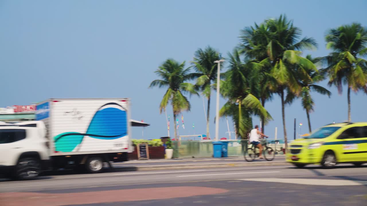 Sunny day with Palms trees, tourists, cars on Ipanema Beach in Rio De Janeiro, Brazil