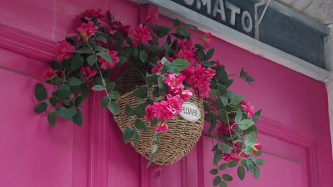 pink door with hanging flower basket