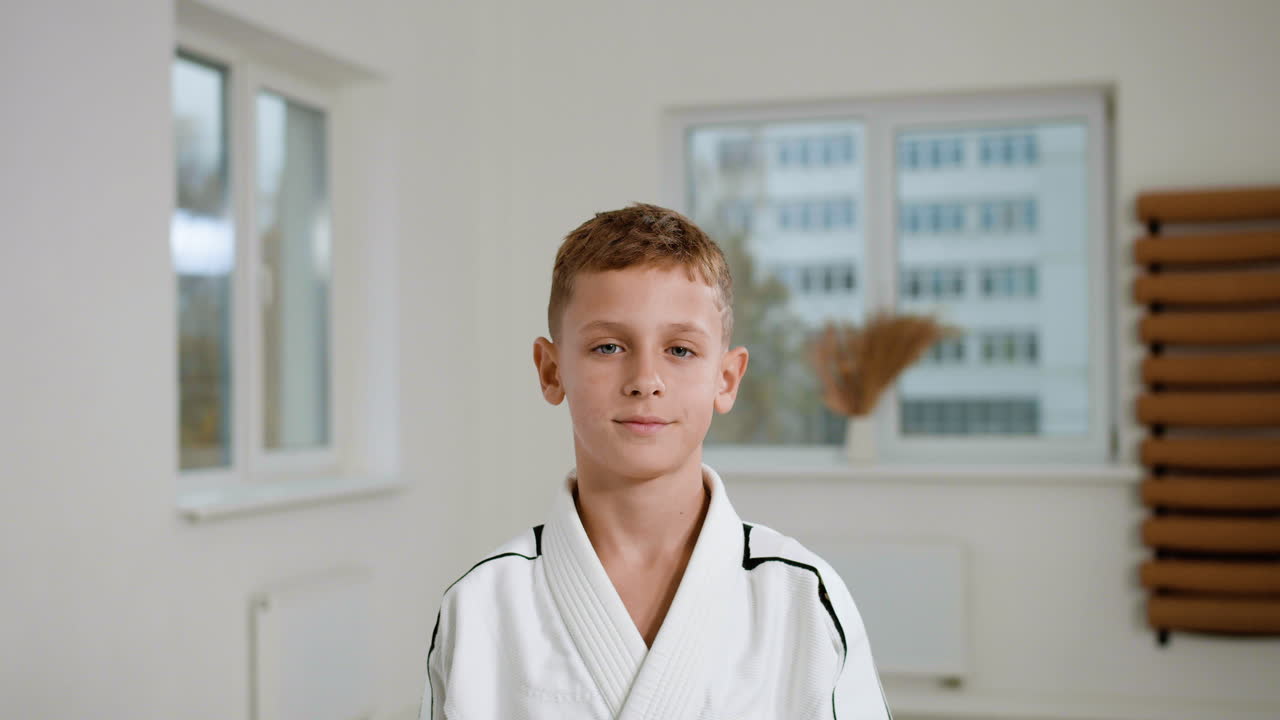 мальчик в белом кимоно в классе боевых искусств