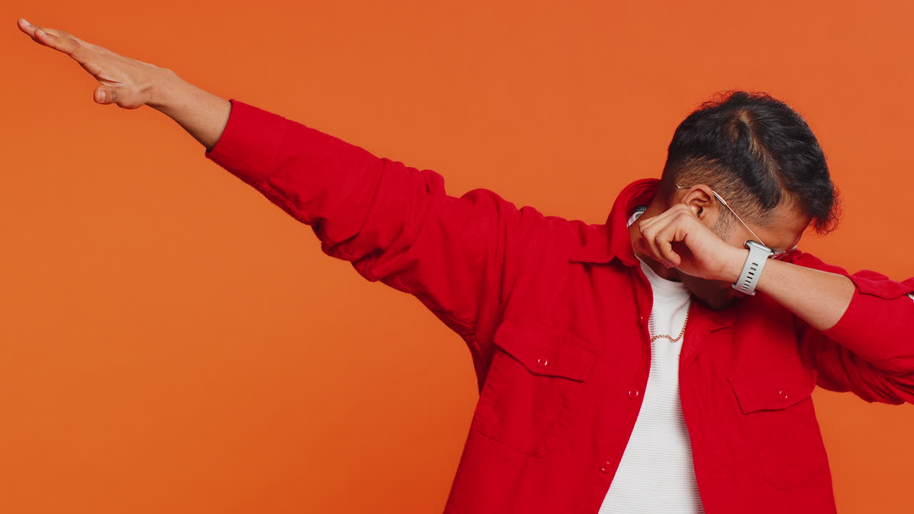Happy indian man having fun dancing moving to rhythm dabbing raising hands making dub dance gesture