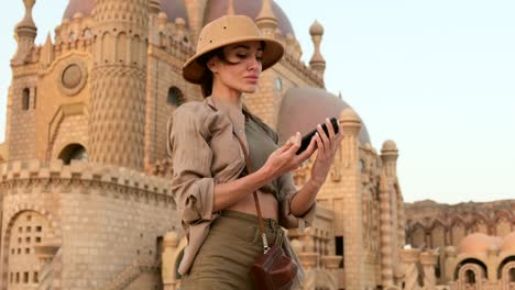 una turista se toma una foto contra el fondo de una mezquita, india