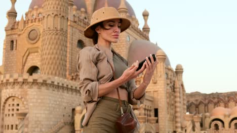 tourist takes a photo of herself against the background of a mosque, india