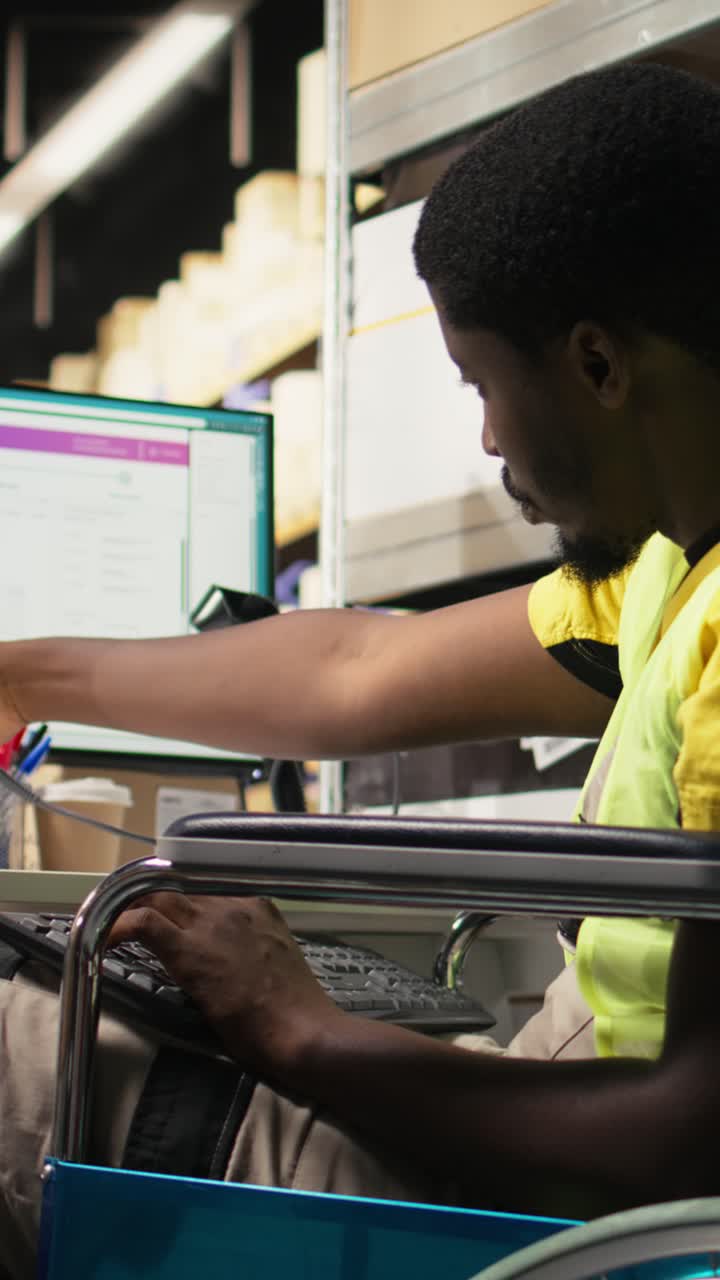 Vertical Video African american wheelchair user works on package tracking info in depot