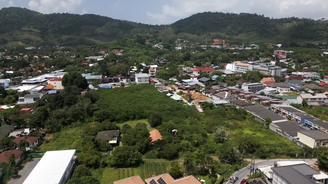 Aerial drone view of a traditional village in Phuket, Thailand, with lush greenery and tiled rooftops. beautiful landscape of Thailand houses and villages. Vacation and travel