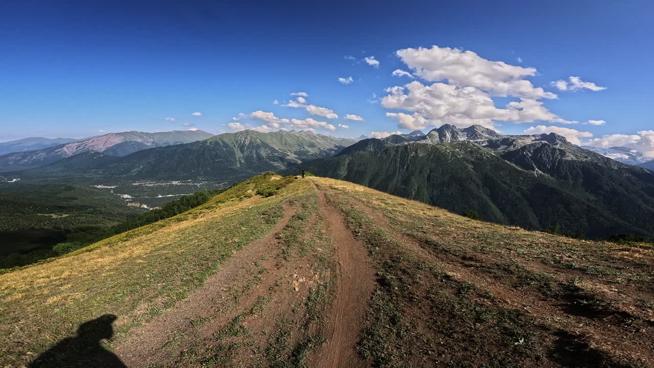 Vista in prima persona mentre si cammina su un sentiero panoramico su una cresta di montagna