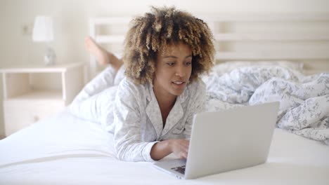 Frau-Schaut-Zu-Hause-Im-Bett-Auf-Den-Laptop