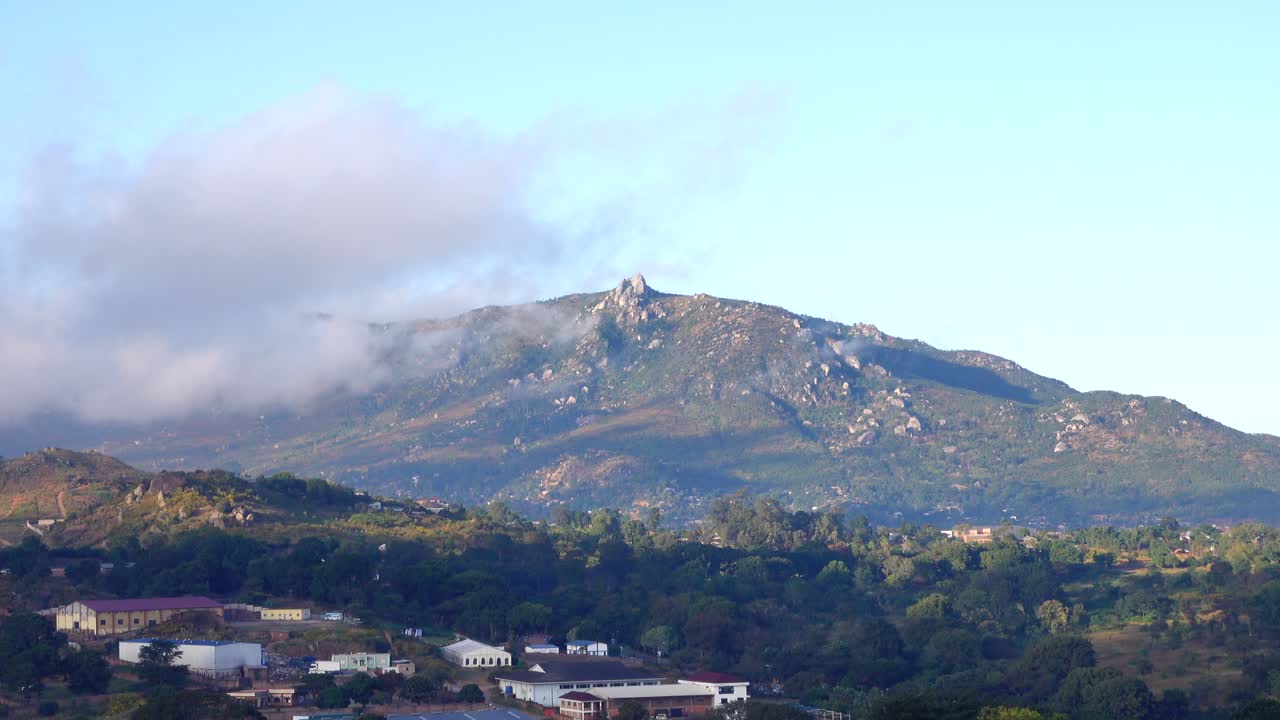 이른 아침에 하늘을 가로질러 움직이는 색색의 구름과 함께 말라위의 한 도시 위로 아름다운 일출