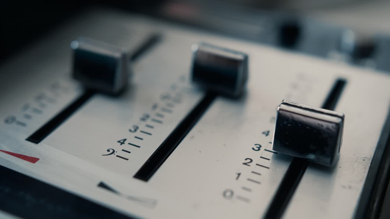 Close-up de Mão Ajustando Faders em um Mixer de Áudio Vintage