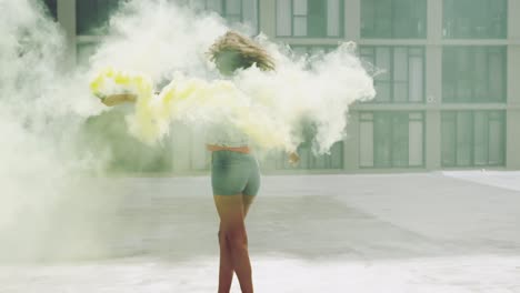 Fashionable-young-woman-on-urban-rooftop-using-a-smoke-grenade