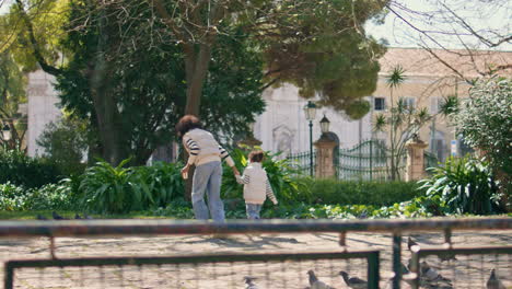 mother daughter running doves looking at birds flying. family having fun