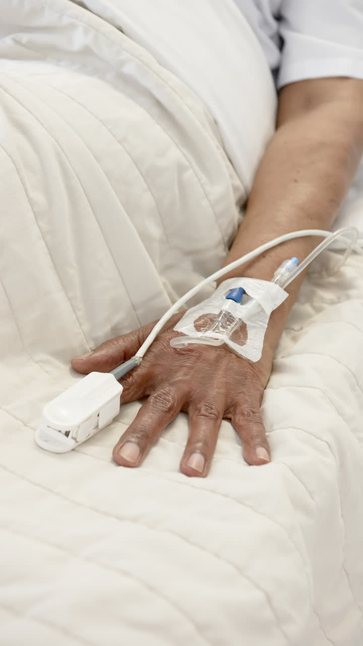Vertical video of senior african american woman hand with intravenou , slow motion, copy space