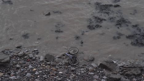 bicycle abandoned in the beach, waves crushing into a bike that was trowed into the sea
