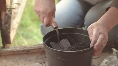 Gardener-preparing-plant-pots-in-wooden-shed