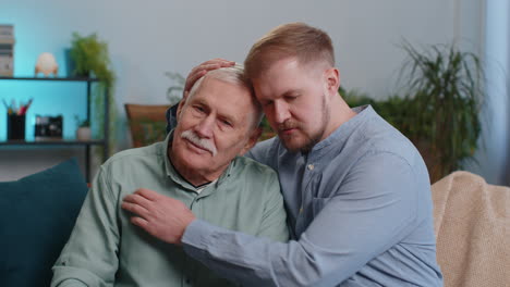 adult man grandson supporting, giving psychological help to ill sick senior grandfather, compassion