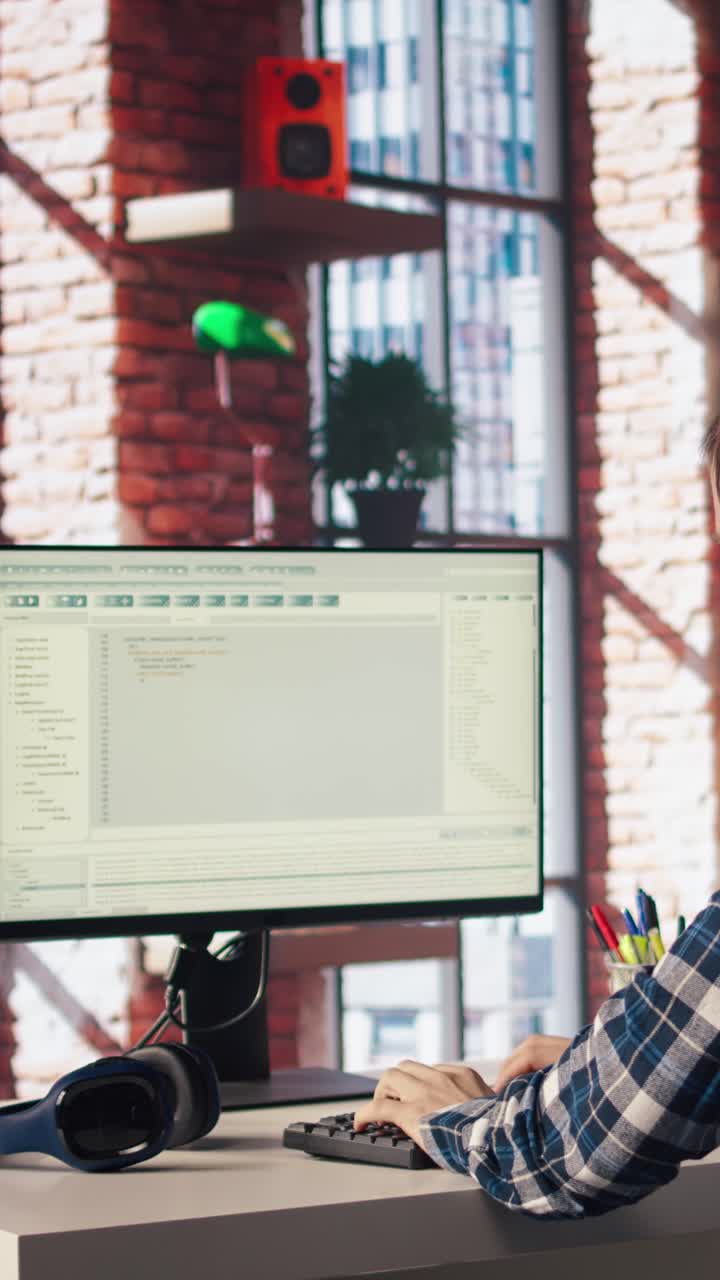 Vertical video Man at home looking at UI on PC screen, typing and executing programming code