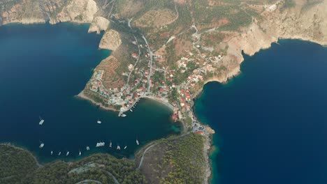 Vista-De-Arriba-Hacia-Abajo-Del-Pueblo-De-Pescadores-De-Assos-Y-El-Castillo-De-La-Cima-De-La-Colina,-Paisaje-De-La-Isla-De-Kefalonia