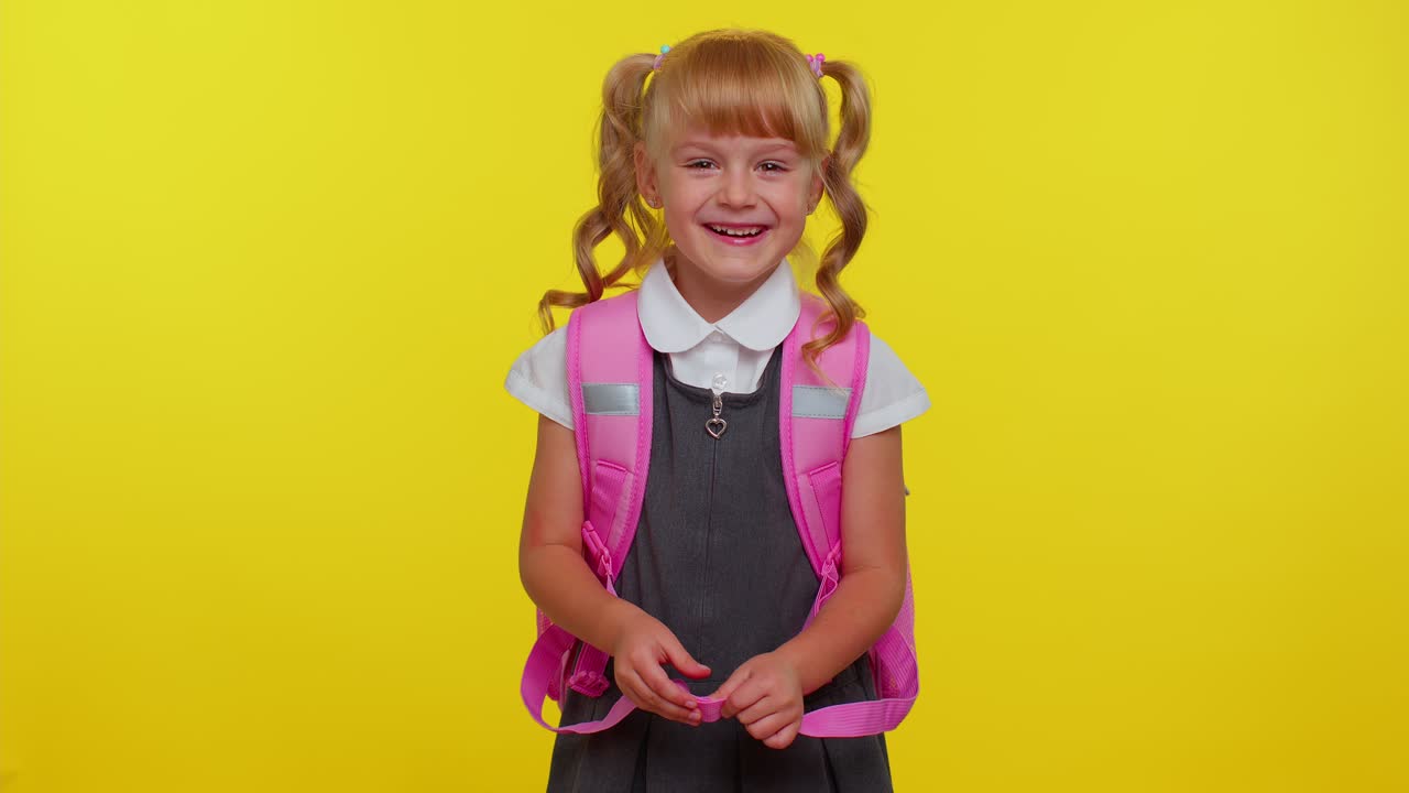 Lächelndes Schulmädchen mit Rucksack lacht lauthals, nachdem es eine absurde Anekdote oder einen lustigen Witz gehört hat.