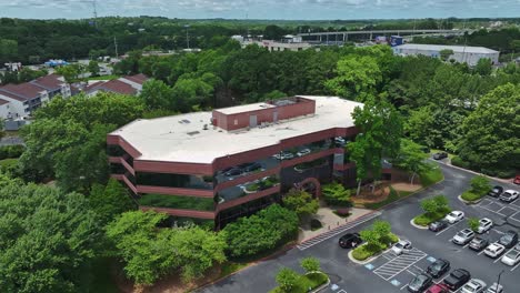 aerial view of red brick and mirrors office building in marietta, atlanta. parking cars at indigo road realty by egypt sherrod