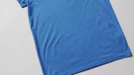 Video-Der-Flachen-Lage-Eines-Blauen-T-Shirts-Mit-Kopierraum-Auf-Weißem-Hintergrund