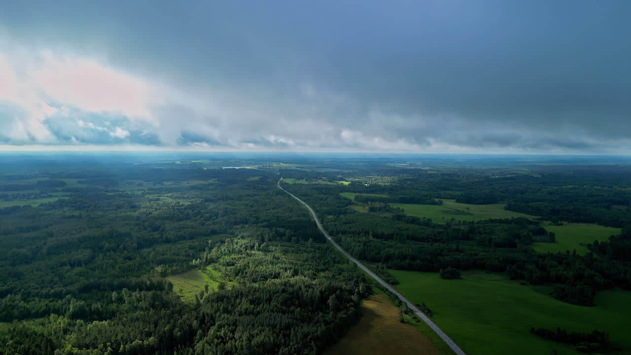 Regenwolken ziehen über bewaldeten Flachlandflächen, Luftaufnahme.