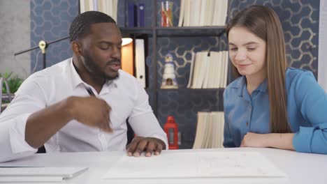 Multiethnic colleagues. Multiethnic company employees sitting at desk in office chatting while working on project while smiling.