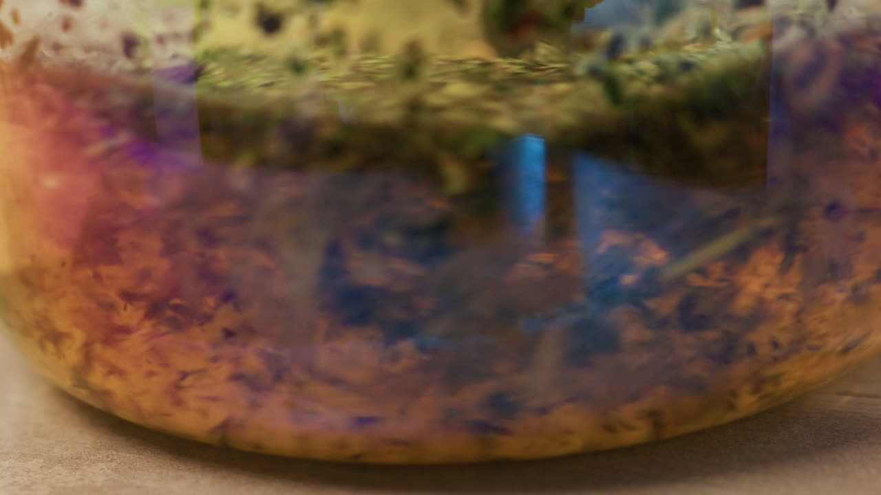 Primo piano di campana tibetana iridescente con riflesso strutturato. Toni caldi di rame e ottone si fondono con patina viola e blu, creando un luccichio tranquillo. La scena suggerisce un allestimento per terapia del suono e massaggio in spa.