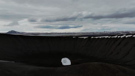 Aerial-shot-of-Hverfjall-volcano's-vast-crater,-offering-a-unique-perspective-of-Iceland's-rugged-and-untouched-terrain