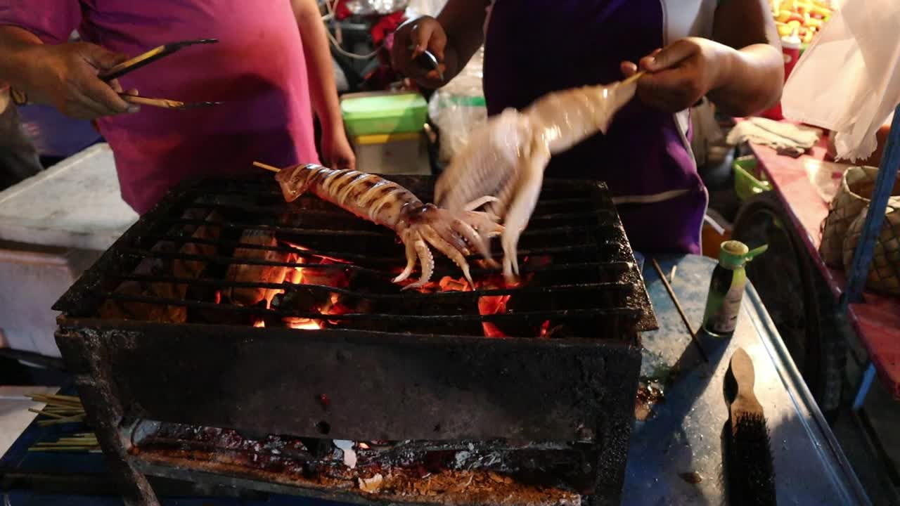 Popular Saturday Night Market Street Food in Chiang Mai, Thailand. Fresh Thai seafood street food cooked on a grill. A lively and fun night market