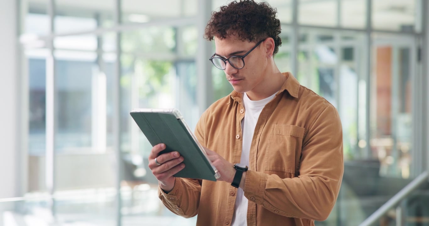Young Man Using a Digital Tablet in a Modern Office