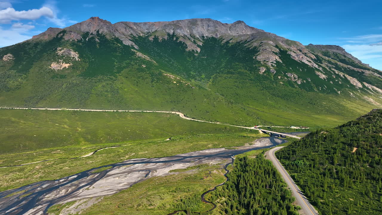 Exploring the vast wilderness of Alaska. Majestic mountains rise above winding rivers and lush green forests, inviting adventures in the Alaskan landscape