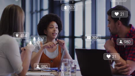 animation of media icons over diverse business people during meeting