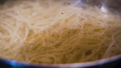 chef adding spices into a pot of soup in slow motion