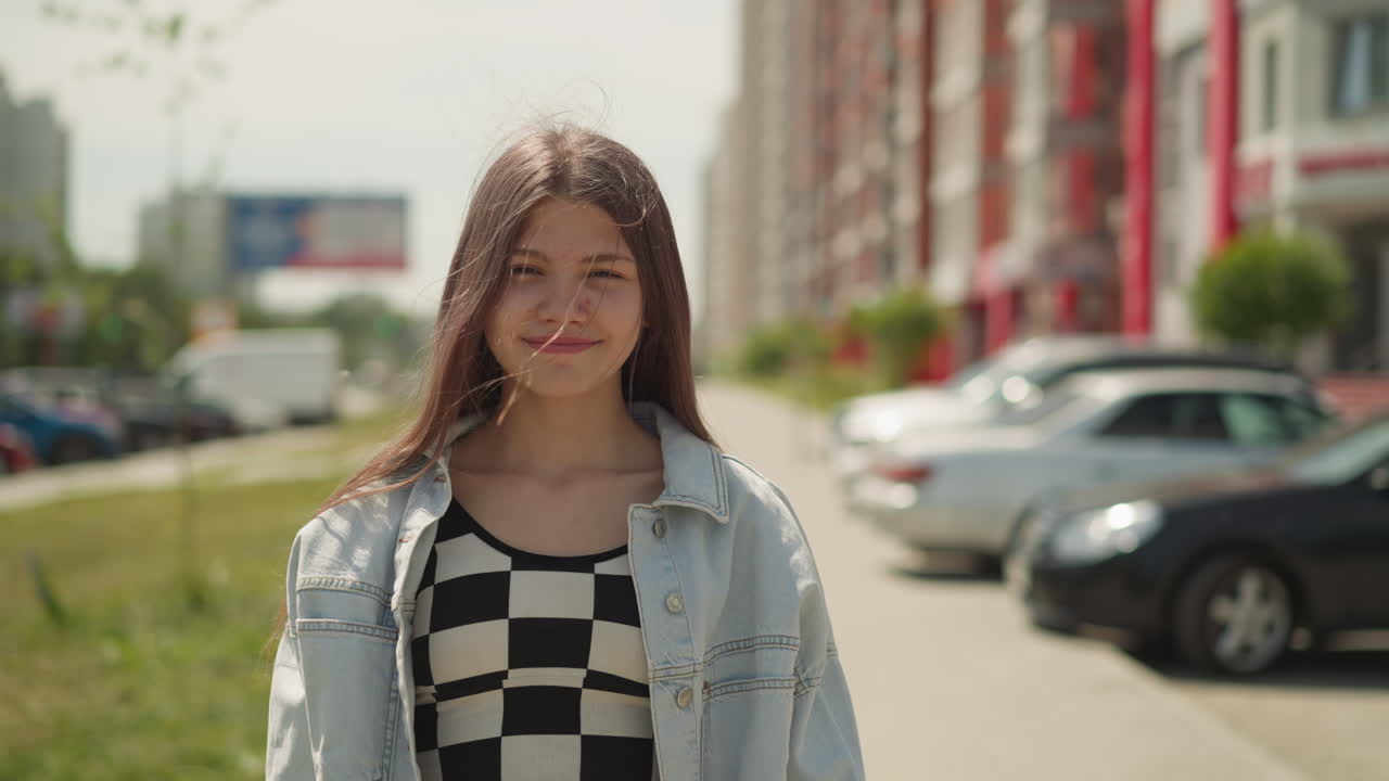 Ragazza adolescente carina con i capelli lunghi sorride camminando per strada