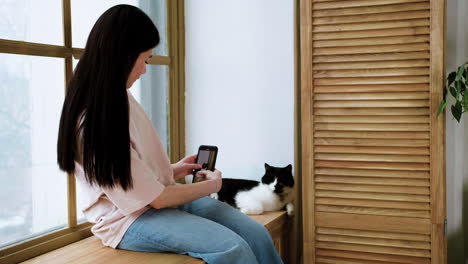 woman recording video of cat