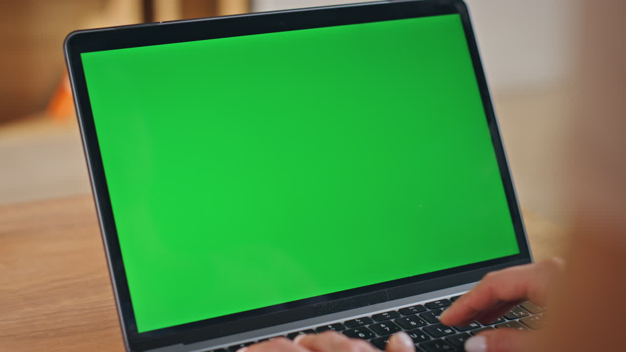 Unrecognized woman typing chroma key laptop keyboard at work desk close up.