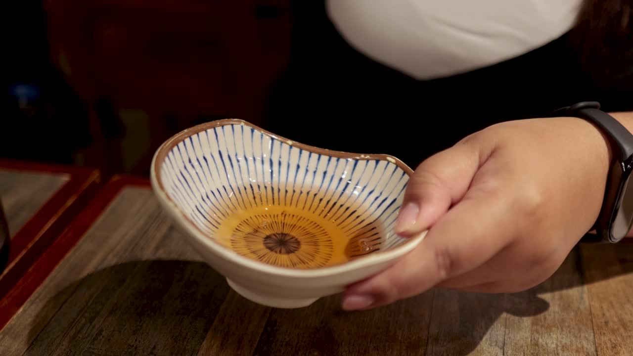 persona vertiendo líquido en un cuenco decorativo