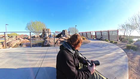 red haired male photographing mandarin duck at mansel crater park in queen creek arizona.