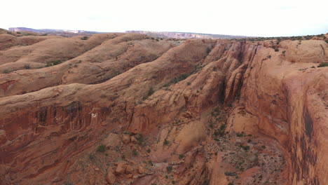 Vista-Aérea-De-Acantilados-Rocosos-De-Arenisca-Y-Cañones-De-Tragamonedas-Del-Desierto-De-Utah,-Disparo-De-Drones