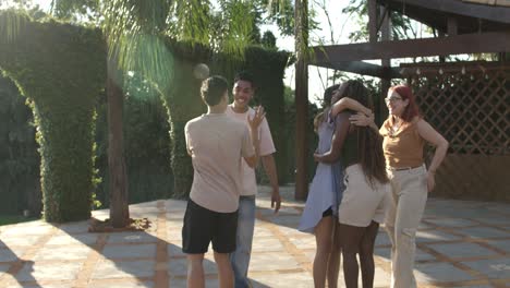 Friends Greeting and Hugging at an Outdoor Social Gathering