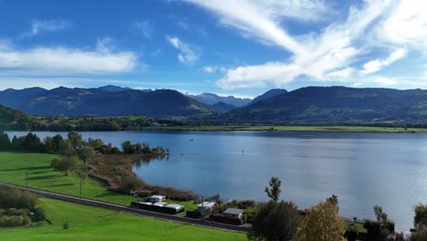 aerial view of green landscape and blue skies with view of zurich lake near bollingen, switzerland