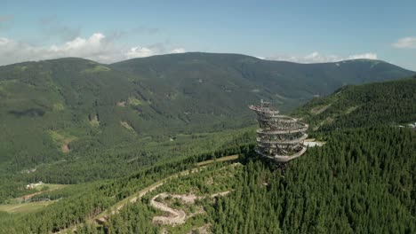 elevación aérea desde el punto de vista de un dron de una atracción de la torre sky walk en dolni morava, república checa y un sendero para bicicletas mtb cercano