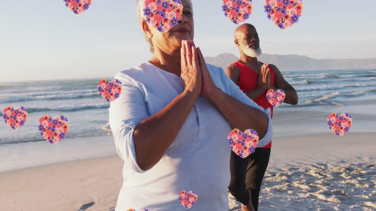 animación de iconos de corazón sobre una pareja de ancianos afroamericanos practicando yoga en la playa