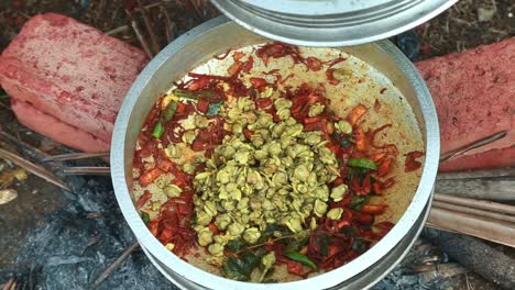 black clam masala curry ,traditional outdoor, black clams cooking, pollution , masala , brick , transfer the cooked meat to another bowl